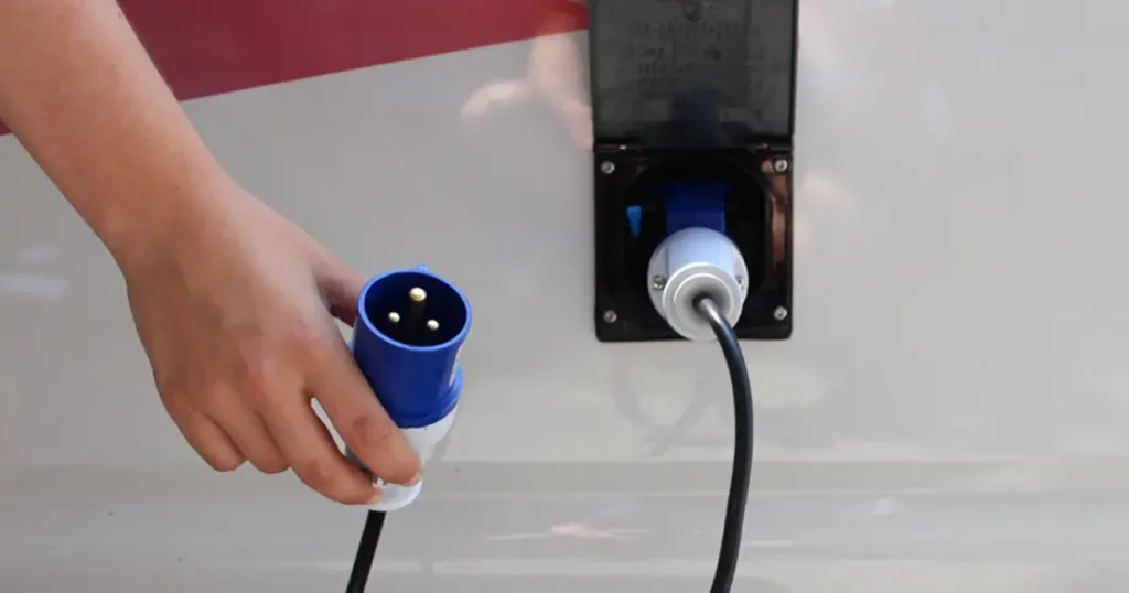 Adaptateur de prise électrique pour camping-car branché sur une borne